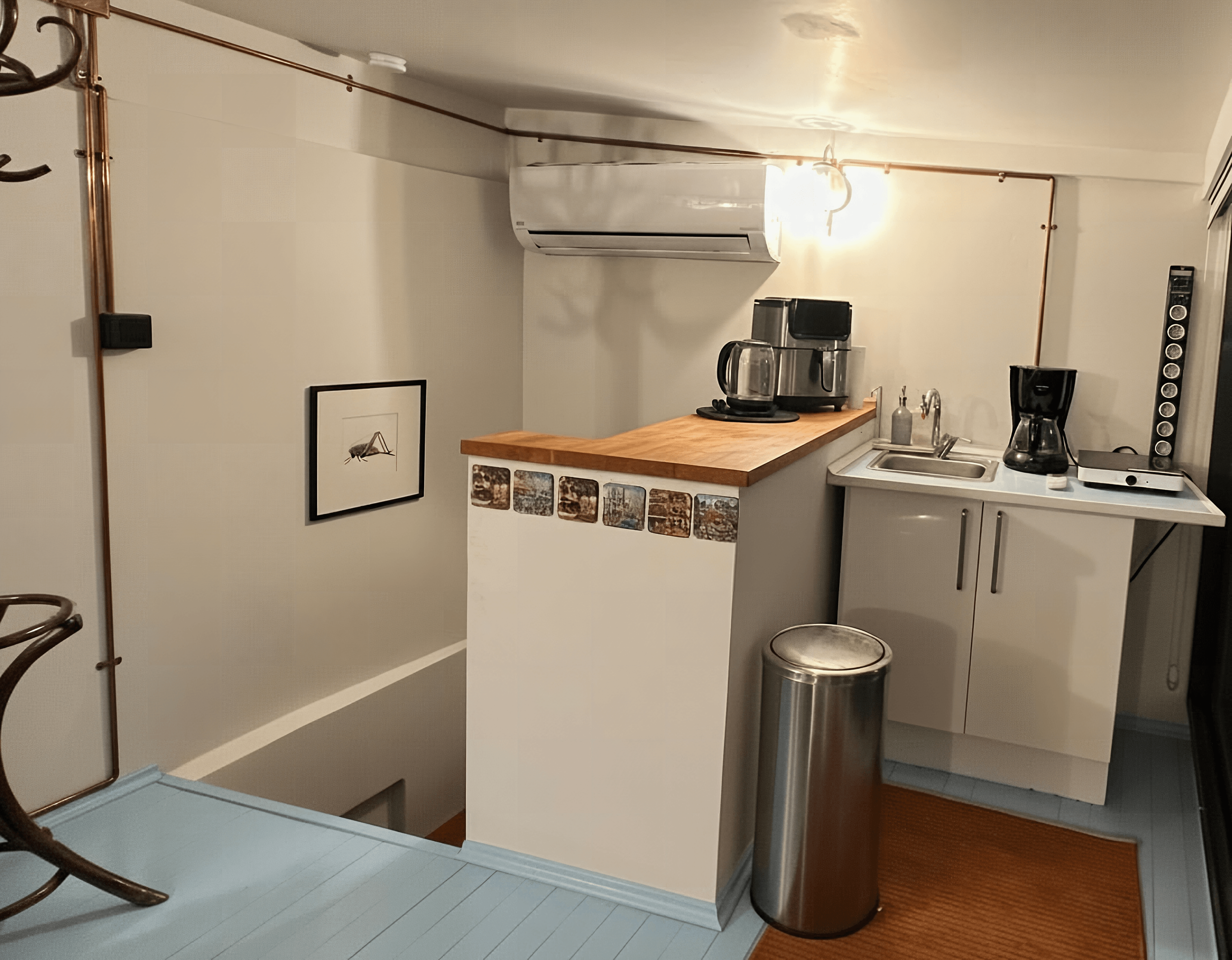 Modern kitchen with copper pipe lighting and coffee makers