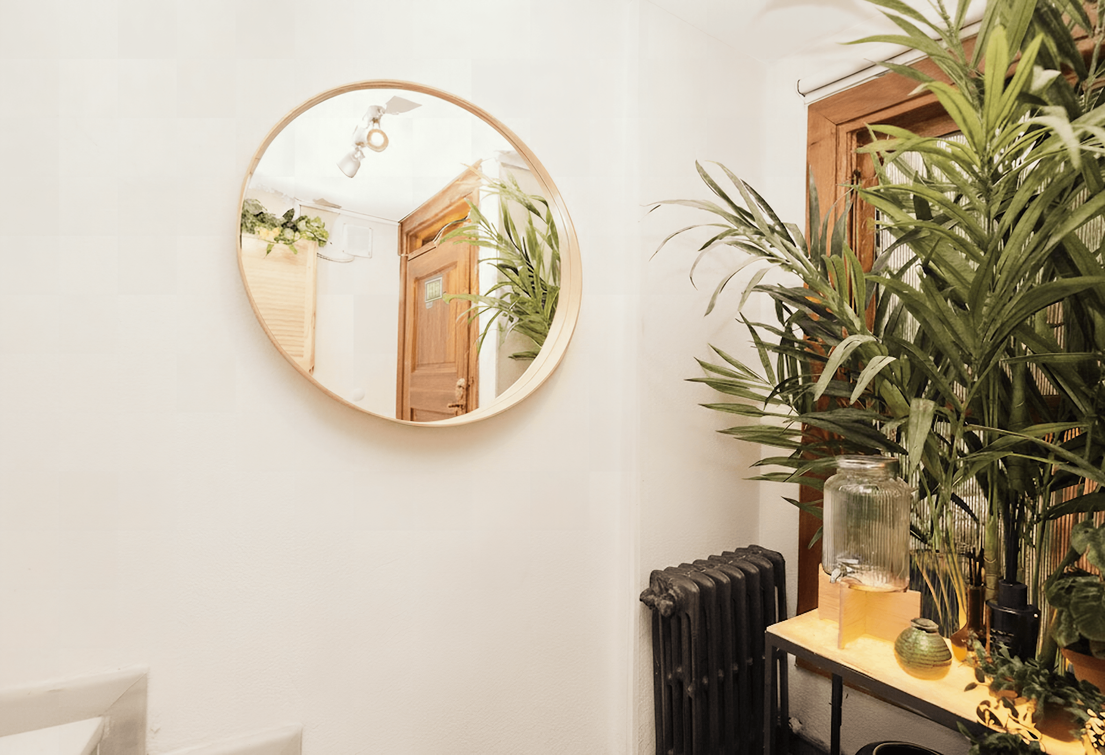 Welcoming entrance with round mirror and palm plant